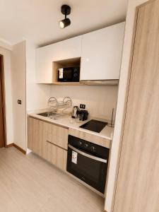 a kitchen with a sink and a stove top oven at Estudio peninsula Cavancha in Iquique +2 photos