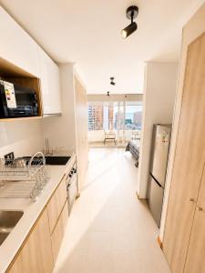 a kitchen with a sink and a refrigerator at Estudio peninsula Cavancha in Iquique