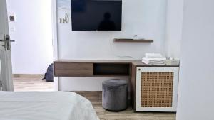 a room with a tv on a wall with a bed at Khách Sạn Lý Sơn Phú Sỹ in Ly Son