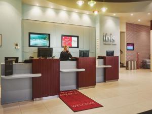a woman standing at a toll booth in a store at Ibis Praha Wenceslas Square in Prague