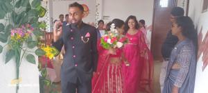 a man standing next to a woman holding a bouquet of flowers at New Hotel Bundala park in Tissamaharama
