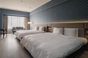 a hotel room with two beds and a chair at T Hotel in Taichung +44 photos