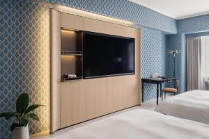 a bedroom with a large tv in a wall at T Hotel in Taichung