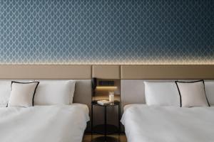 two beds sitting next to each other in a room at T Hotel in Taichung