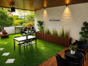 a restaurant with tables and chairs on the grass at Kalarava private rooms in Chikmagalūr
