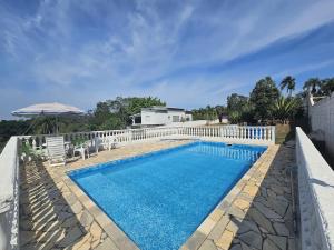 a swimming pool with a white fence around it at Rancho da Benção in São Roque