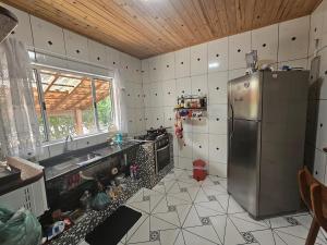 a kitchen with a stainless steel refrigerator and a window at Rancho da Benção in São Roque