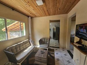 a living room with a couch and a tv at Rancho da Benção in São Roque