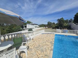 a swimming pool with a table and chairs and an umbrella at Rancho da Benção in São Roque +18 photos