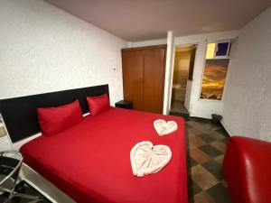 a bedroom with a red bed with two hearts on it at Hotel Boppard in Mexico City