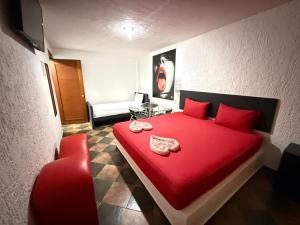 a red bed with red pillows in a room at Hotel Boppard in Mexico City