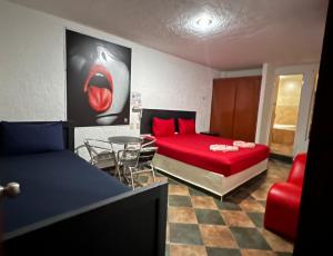a bedroom with a red bed and a table and chairs at Hotel Boppard in Mexico City
