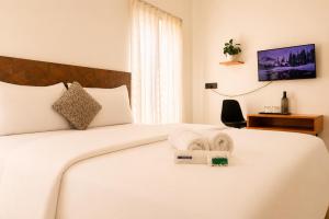 a hotel room with a bed with a towel on it at Kalarava private rooms in Chikmagalūr