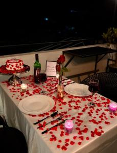a table with red roses on a white table cloth at Kalarava private rooms in Chikmagalūr