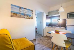 a kitchen and living room with a table and chairs at Alison Apartments in Premantura