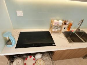 a kitchen counter with a sink and a stove top at Jess Apt in Tuy Hoa