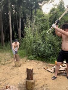two men are chopping up trees with a pole at ログハウス1棟貸し,持込み自由,サウナ,露天風呂にバーべキュウや薪割り,ソーメン流しに収穫体験が楽しめます in Kashima +67 photos