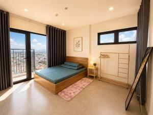 a bedroom with a bed and large windows at Jess Apt in Tuy Hoa