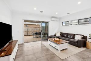 a living room with a couch and a tv at Point Retreat in Point Lonsdale