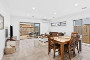 a dining room and living room with a table and chairs at Point Retreat in Point Lonsdale