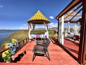 a deck with a gazebo and a chair on the water at Titicaca House Mariela in Puno