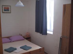 a small bedroom with a bed and a window at Nevera Apartments Pašman,Banj in Banj +34 photos