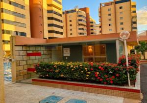 a building with a flower garden in front of it at Caldas novas - Parque das Água Quentes - Conforto e lazer completo -Edi Locações in Caldas Novas