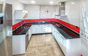 a kitchen with white cabinets and red counter tops at Taurus 13 in Jun