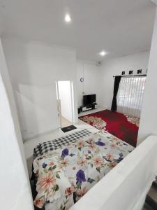 a bedroom with a bed with a floral bedspread at UnitA 5BR Kangen Homestay Jambon Yogyakarta in Cebongan