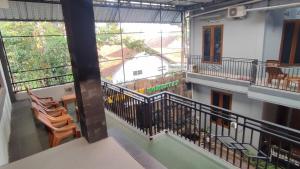 a room with a balcony with chairs and tables at UnitA 5BR Kangen Homestay Jambon Yogyakarta in Cebongan