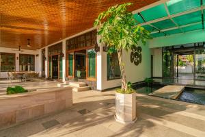 a building with a pool and a tree in front of it at Kiri Anda Villa Phuket in Rawai Beach