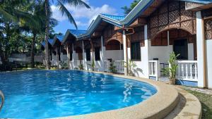 a swimming pool in front of a house at Golden palm rise resort in Libaong +25 photos