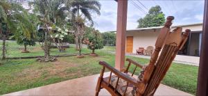 a wooden rocking chair sitting on a porch at Casa de Nivia in Acequias Abajo