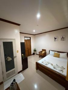 a bedroom with a bed and a room with a door at Golden palm rise resort in Libaong