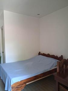 a bedroom with a bed with a blue blanket on it at Bebot's Breakfast #01 in Daanbantayan