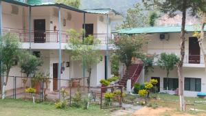 an apartment building with a staircase in front of it at Sheetal Resort and Restaurant in Rudraprayāg