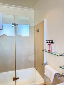 a bathroom with a shower with a glass door at city unit at gouger st in Adelaide +2 photos
