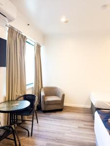 a room with a bed and a table and a chair at city unit at gouger st in Adelaide