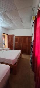 a bedroom with two beds and wooden cabinets at Casa de Nivia in Acequias Abajo