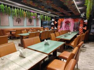 a dining room with tables and chairs and flowers at Hotel Sukhdham in Allahābād
