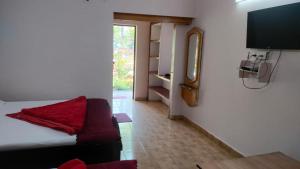 a living room with a couch and a flat screen tv at Sheetal Resort and Restaurant in Rudraprayāg