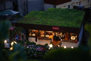 a store with a green roof with people standing outside at Sapa Village Hotel in Sapa