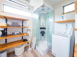 a bathroom with a shower and a washing machine at Mobile Home 8 in Hokuto +29 photos