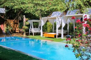 a swimming pool in a yard with a gazebo at The Antique Riverside Resort in Ban Pong