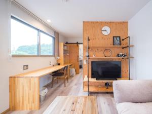 a living room with a desk and a tv in a room at Mobile Home 8 in Hokuto