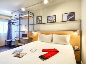 a bedroom with a bed with a red robe on it at ibis Lorient Centre Gare in Lorient +158 photos
