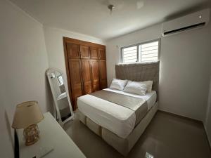 a small bedroom with a bed and a window at Elegant and comfortable and exclusive first level in Santo Domingo