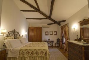 a bedroom with a bed and a dresser in a room at Hotel Lucrezia in Riola Sardo
