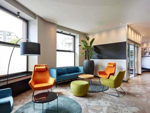 eine Lobby mit Stühlen, einer Couch und einem Tisch in der Unterkunft Mercure Hotel Düsseldorf City Center in Düsseldorf