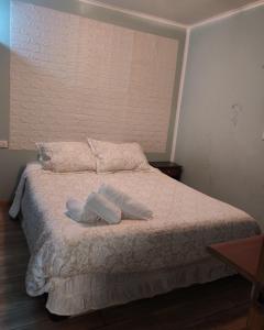 a bed with two white towels on top of it at Casa hospedaje en el campo in Temuco